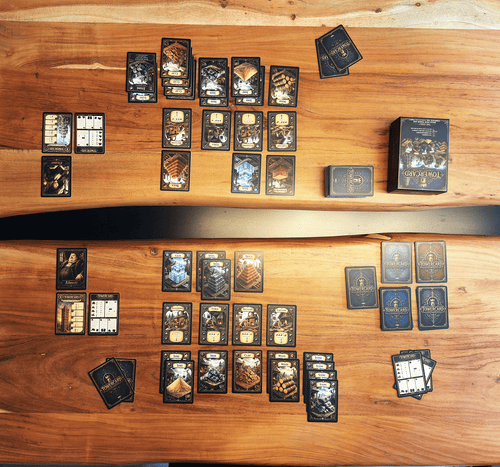 Ein Bild aus der Vogelperspektive zeigt den Spieleaufbau von TowerCard. Erste Reihe vor dir POV die einfachen Ressourcen. Zweite reihe darüber die Produktionsgebäude und die dritte Reihe darüber die verarbeiteten hochwertigen Ressourcen.